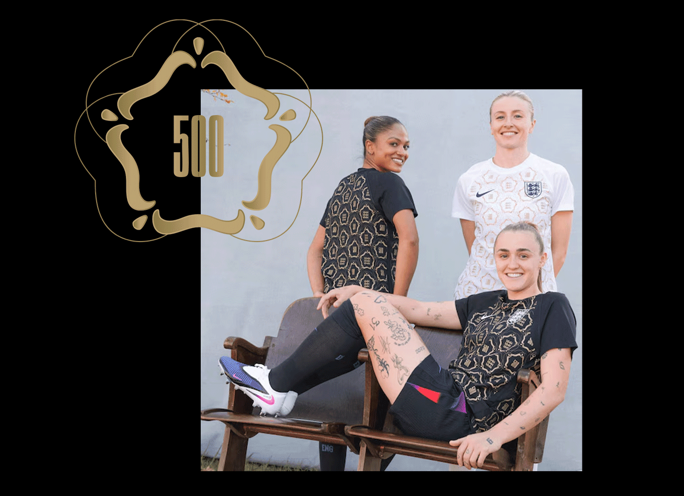 Three female soccer players in England kits posing; one seated with tattoos visible on legs and arms.