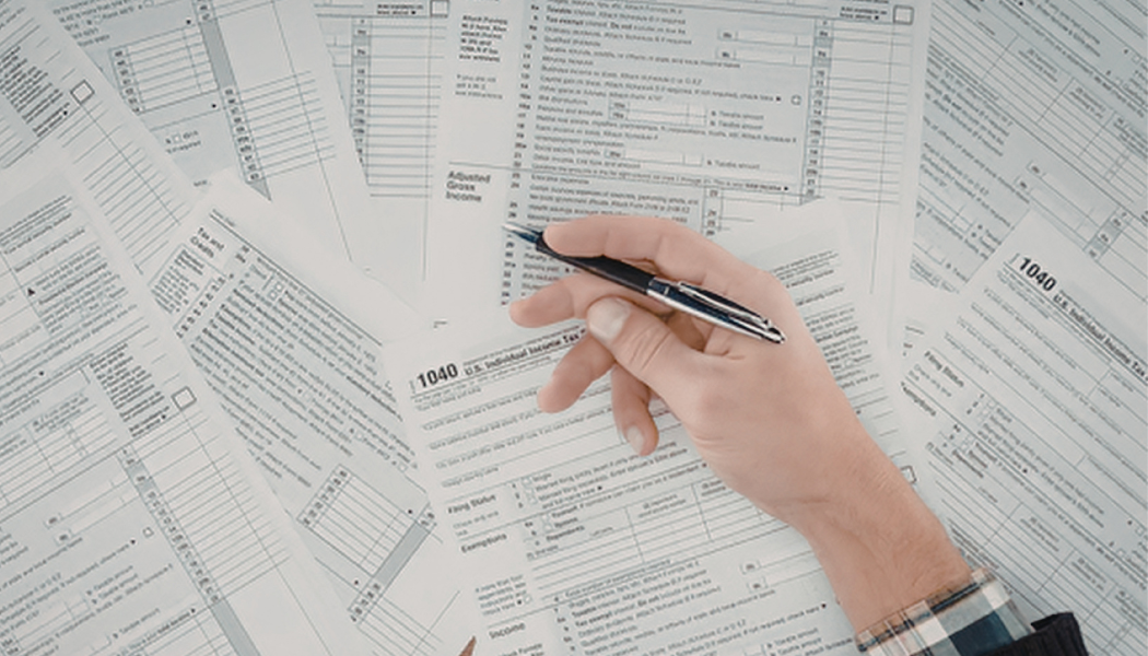 personne avec plusieurs documents comptables sur la table