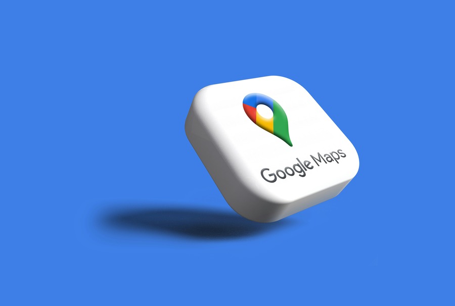 3D Google Maps app icon with a colorful pin logo (blue, red, yellow, green) on a white background, floating against a blue backdrop, highlighting navigation features.