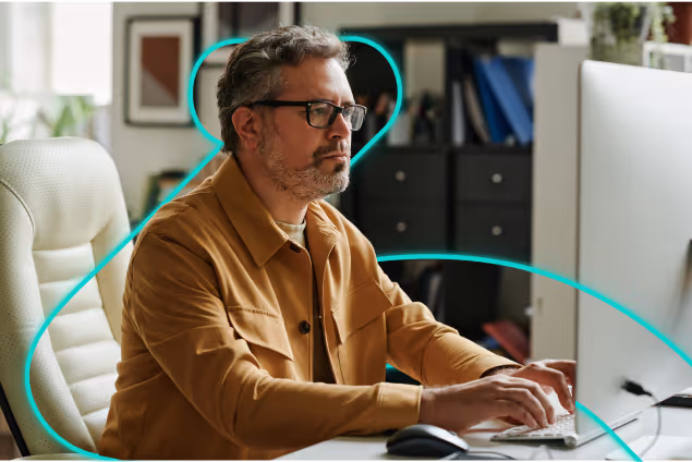 a man sitting at a desk typing on a computer