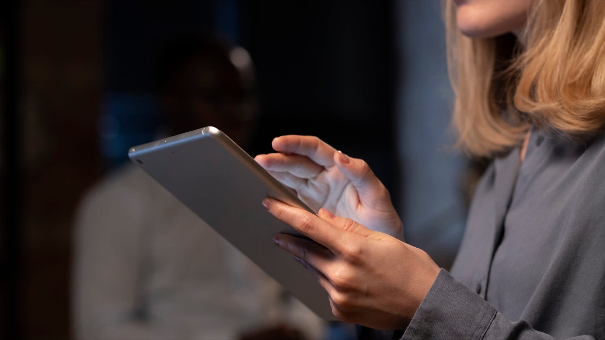 A compliance professional reviewing a SOC 2 report on a tablet during a vendor security assessment.