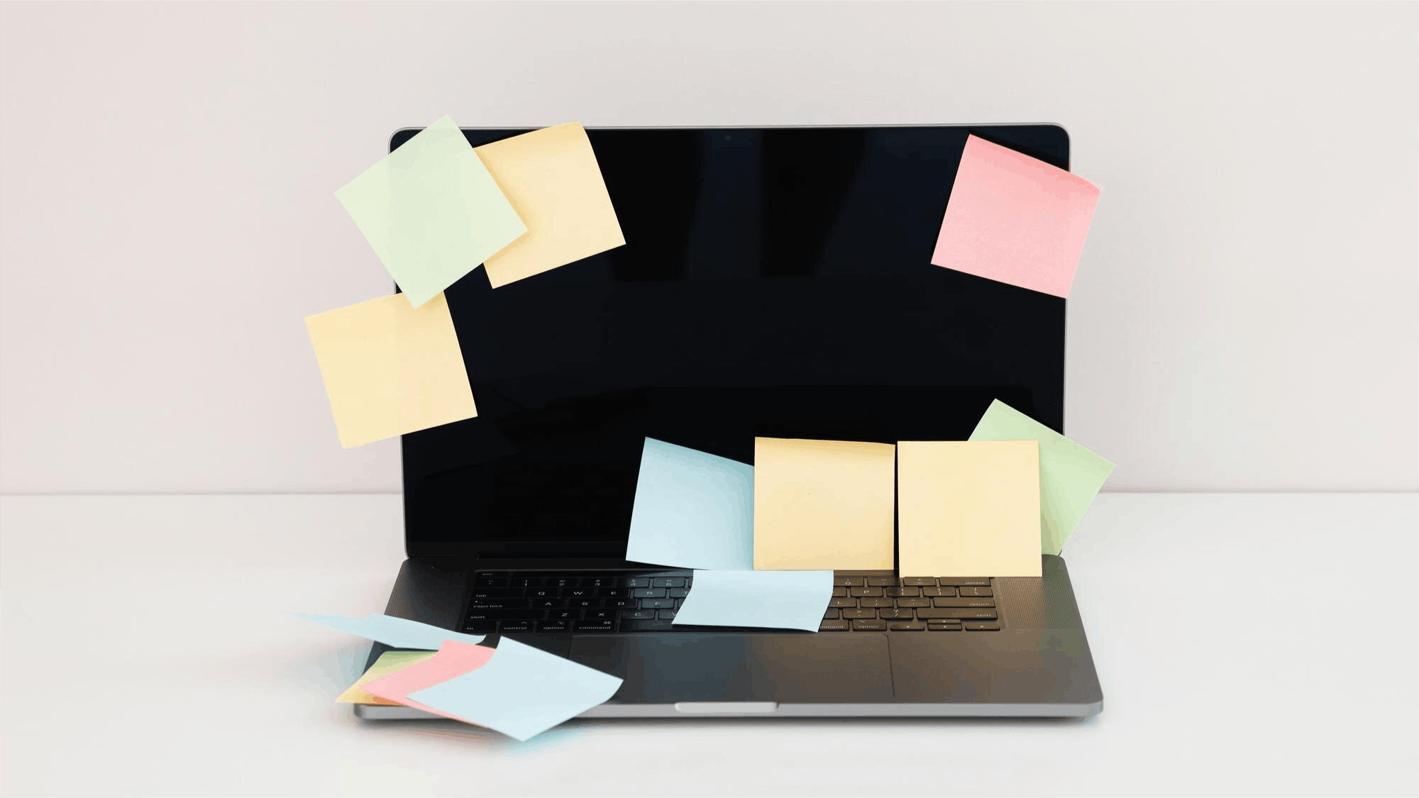 A laptop covered in colourful sticky notes representing disorganised compliance management, illustrating how compliance software becomes shelfware without proper adoption.
