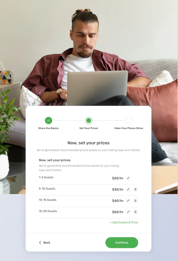 A man sitting on a couch looking at a laptop.