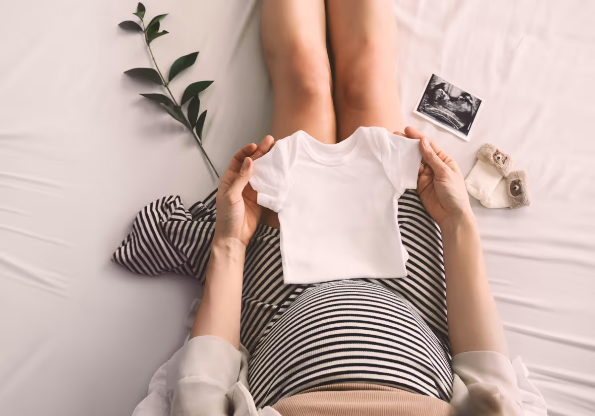 Embarazada con ropa de bebé
