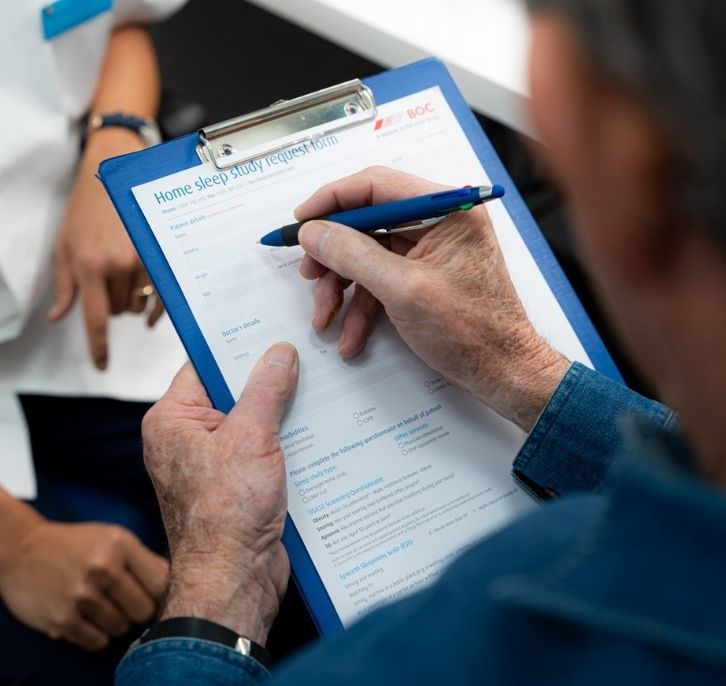A person filling Sleep study request form in amcal pharmacy moorebank