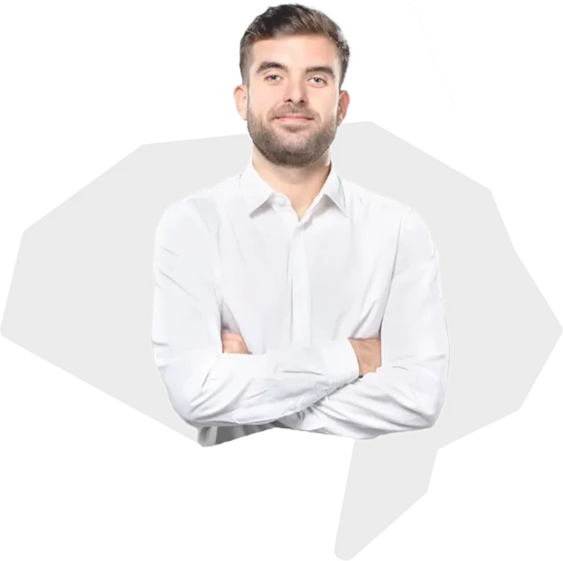 Man with beard and short hair wearing a white button-up shirt, standing with arms crossed and smiling slightly.