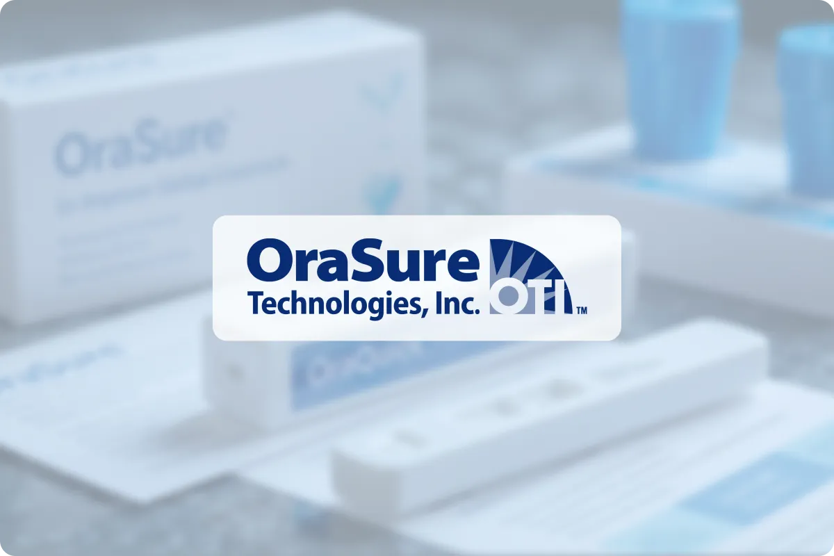 Logo of OraSure Technologies, Inc. prominently displayed over a blurred background featuring diagnostic medical testing kits and blue specimen collection devices. The logo includes bold blue text and a stylized semicircle design with radiating lines and th