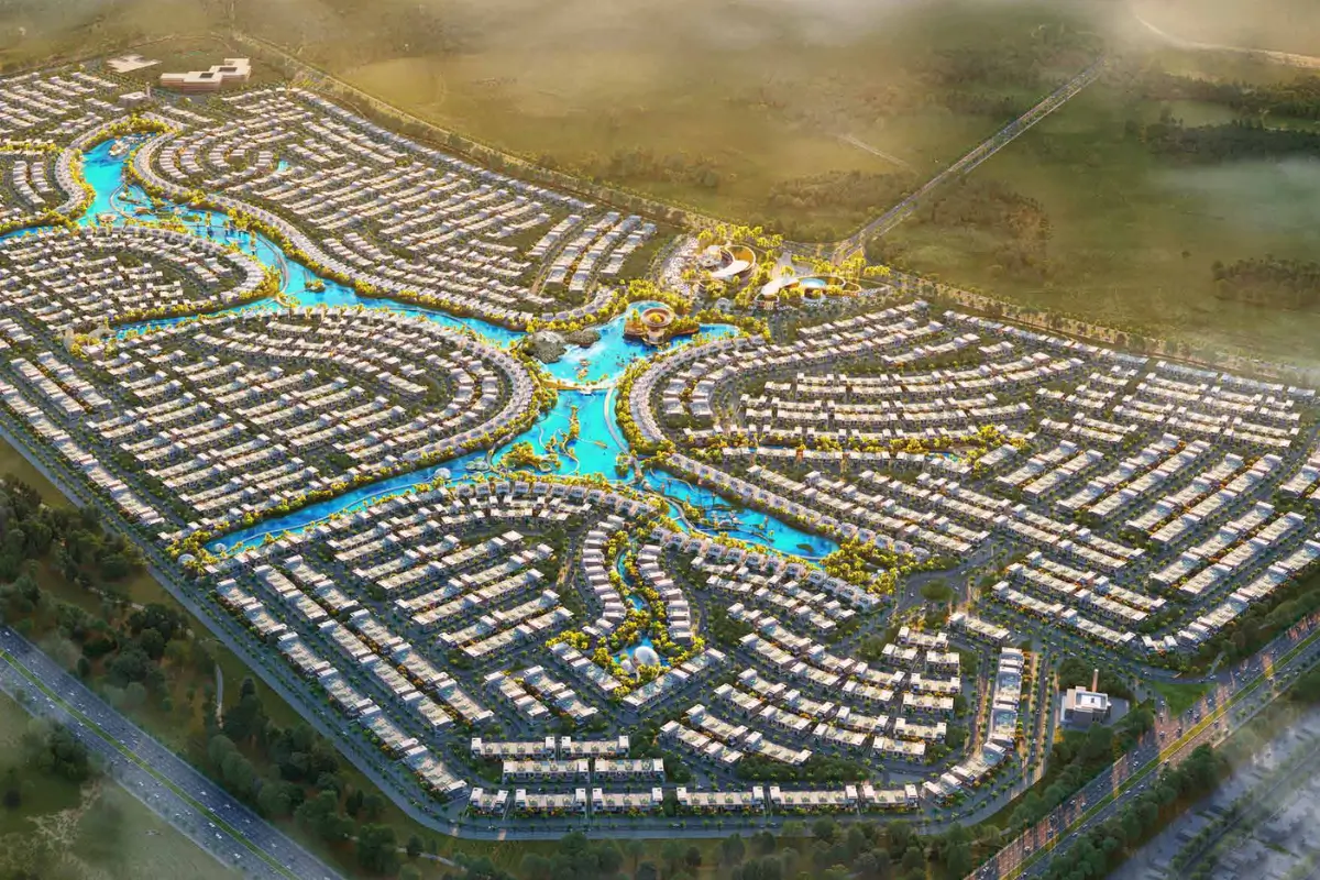 Aerial view of a large residential neighborhood with curved streets and blue water canals running through the center.