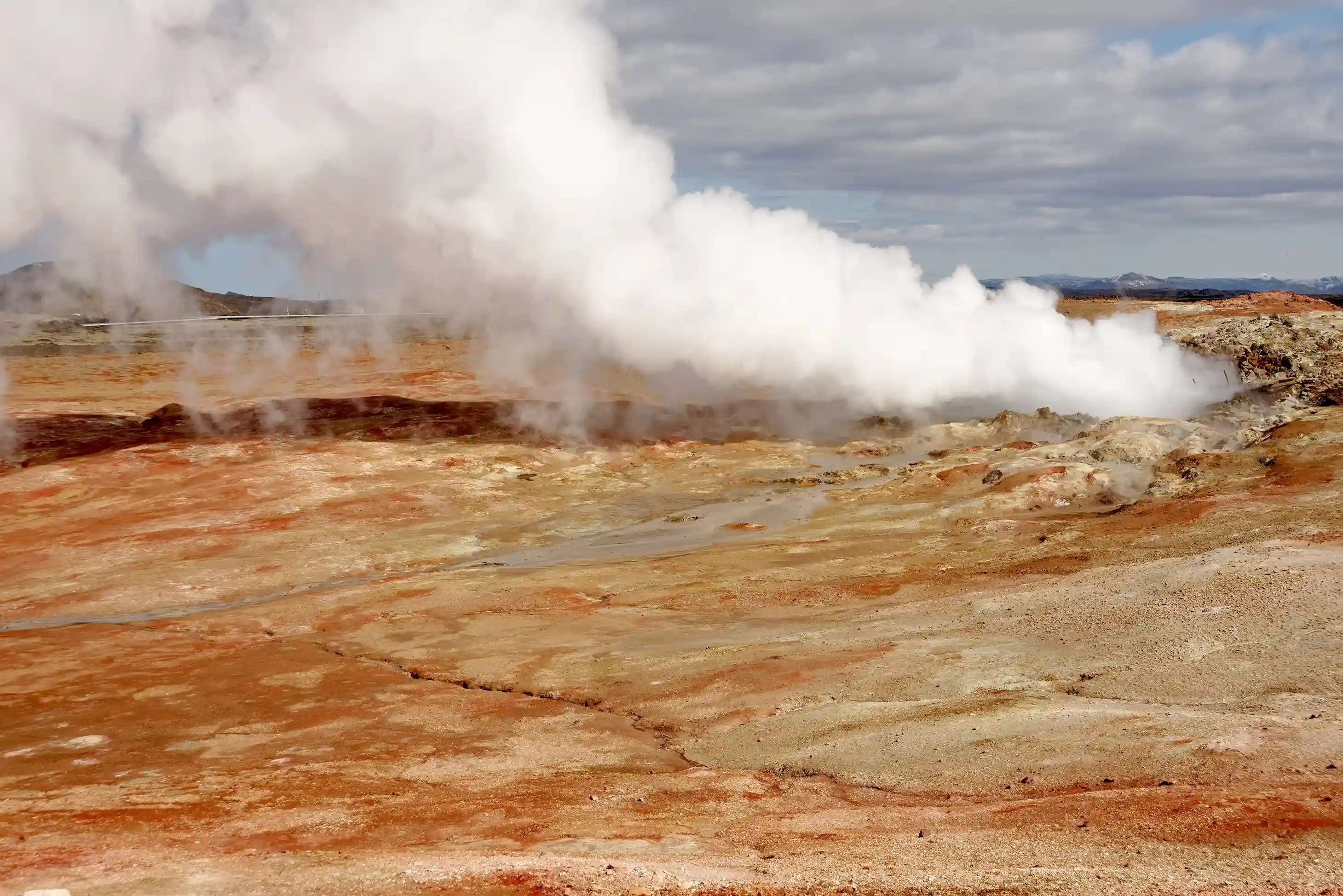 Gunnuhver boiling mud pool with dense white steam rising above dark volcanic terrain, southwest Reykjanes Peninsula