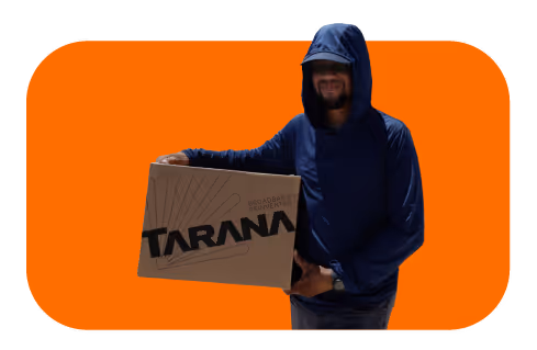 Person wearing a blue hoodie holding a cardboard box labeled 'TARANA'.