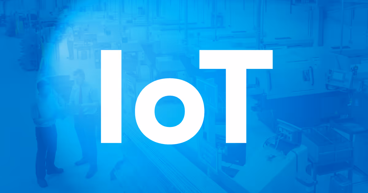 Large white text 'IoT' overlaid on a blue-toned factory or industrial workspace background with two workers discussing.