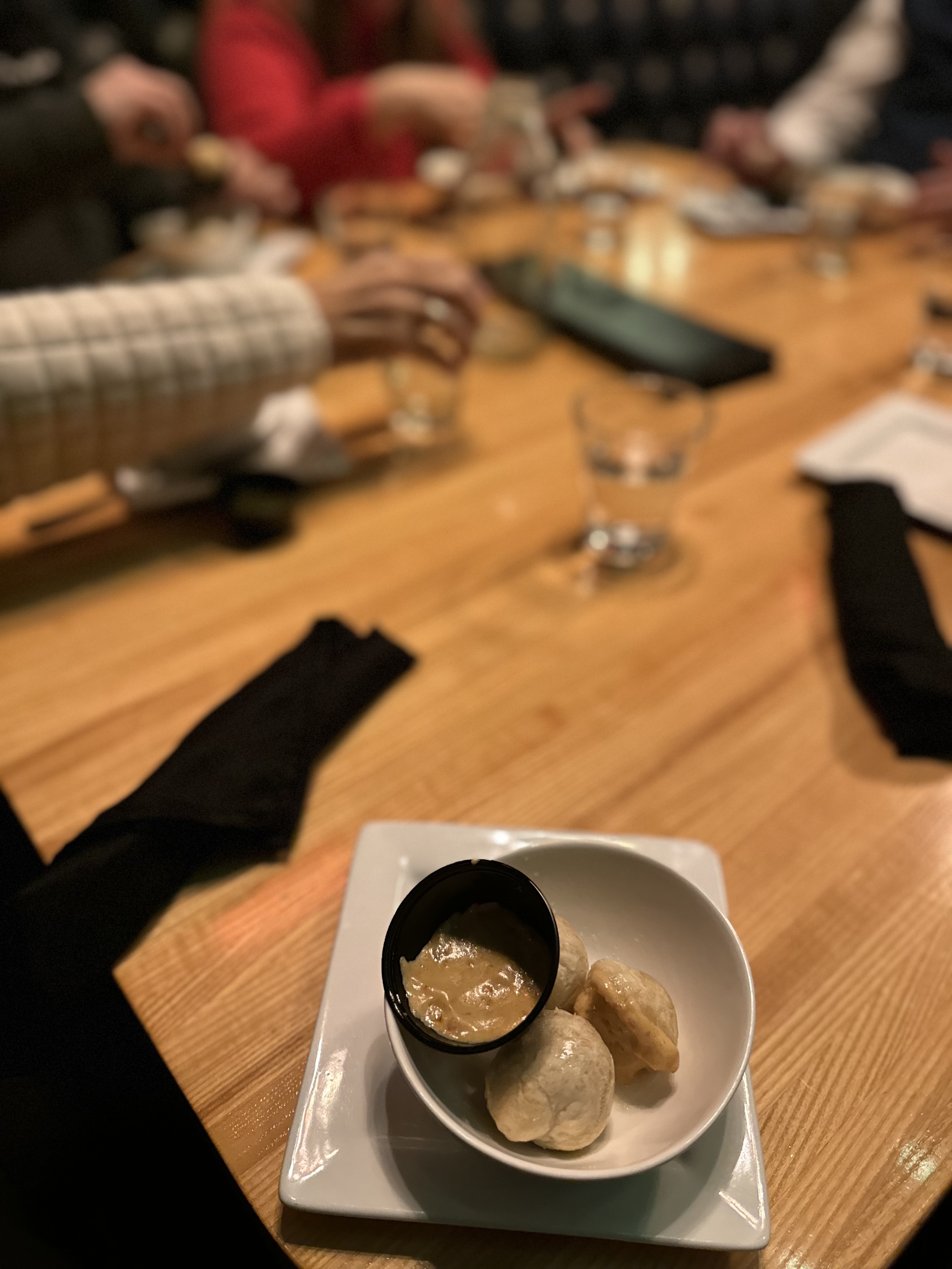 A plate of succulent shrimp with a creamy dipping sauce, served alongside cheesy macaroni and a crisp vegetable roll