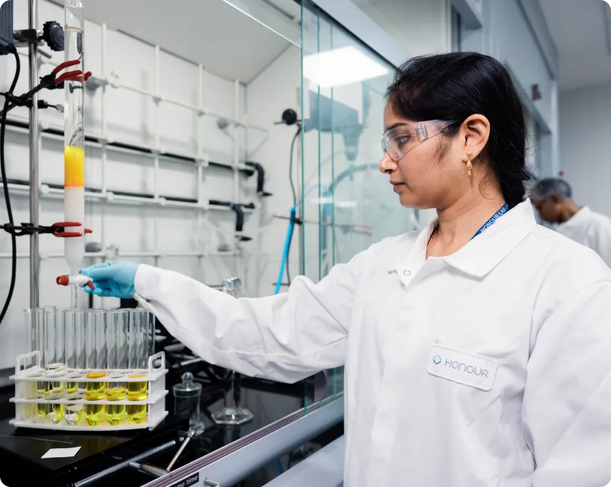 Lab technician wearing personal protective equipment while working in a controlled environment