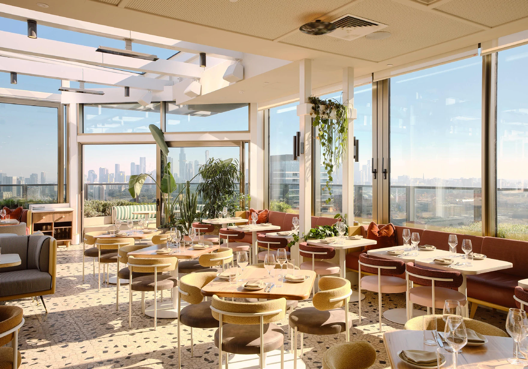 Sunlight across Beverly’s rooftop dining room, with Melbourne skyline views