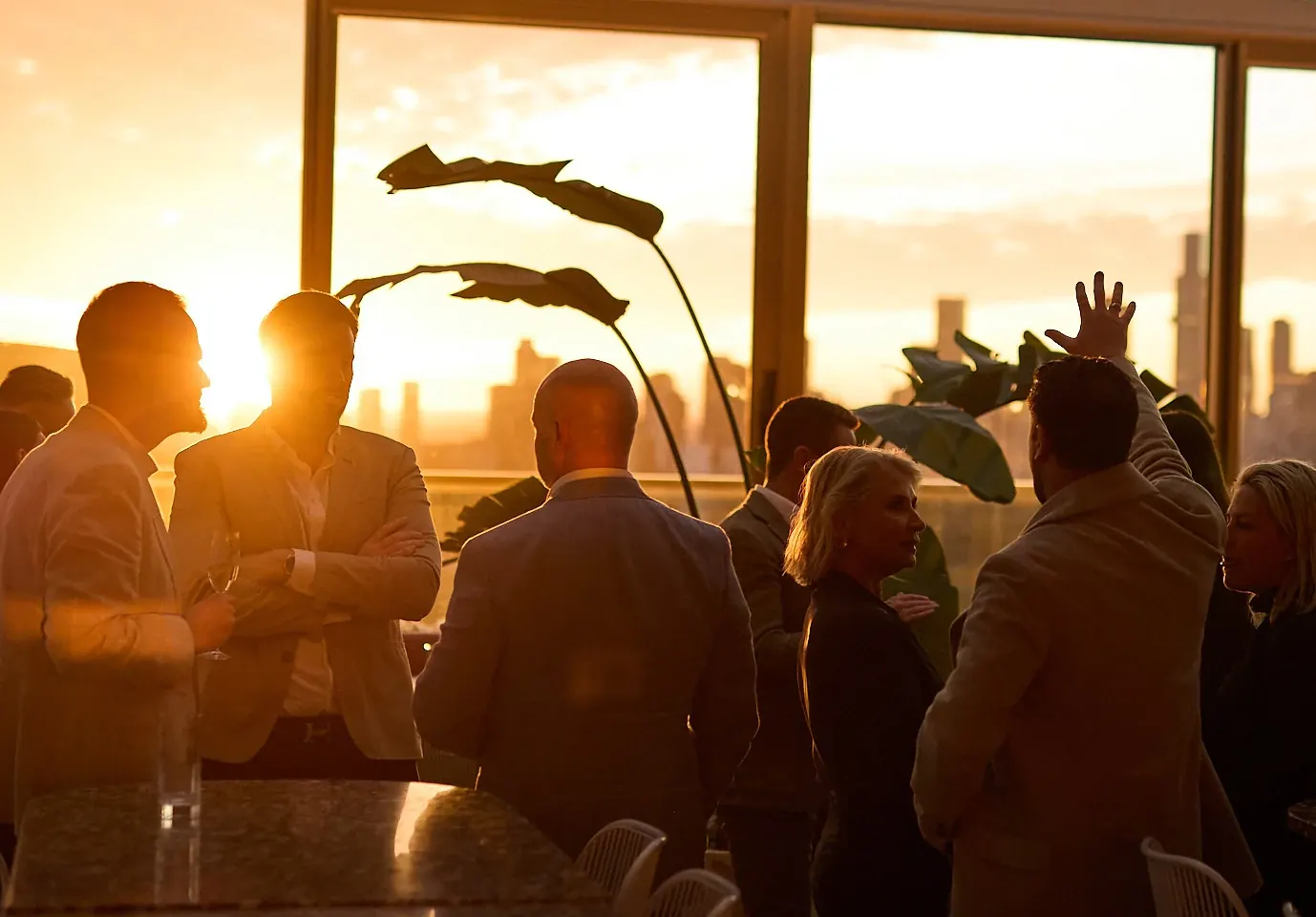 Guests gathering over drinks at Beverly as the sun sets over Melbourne