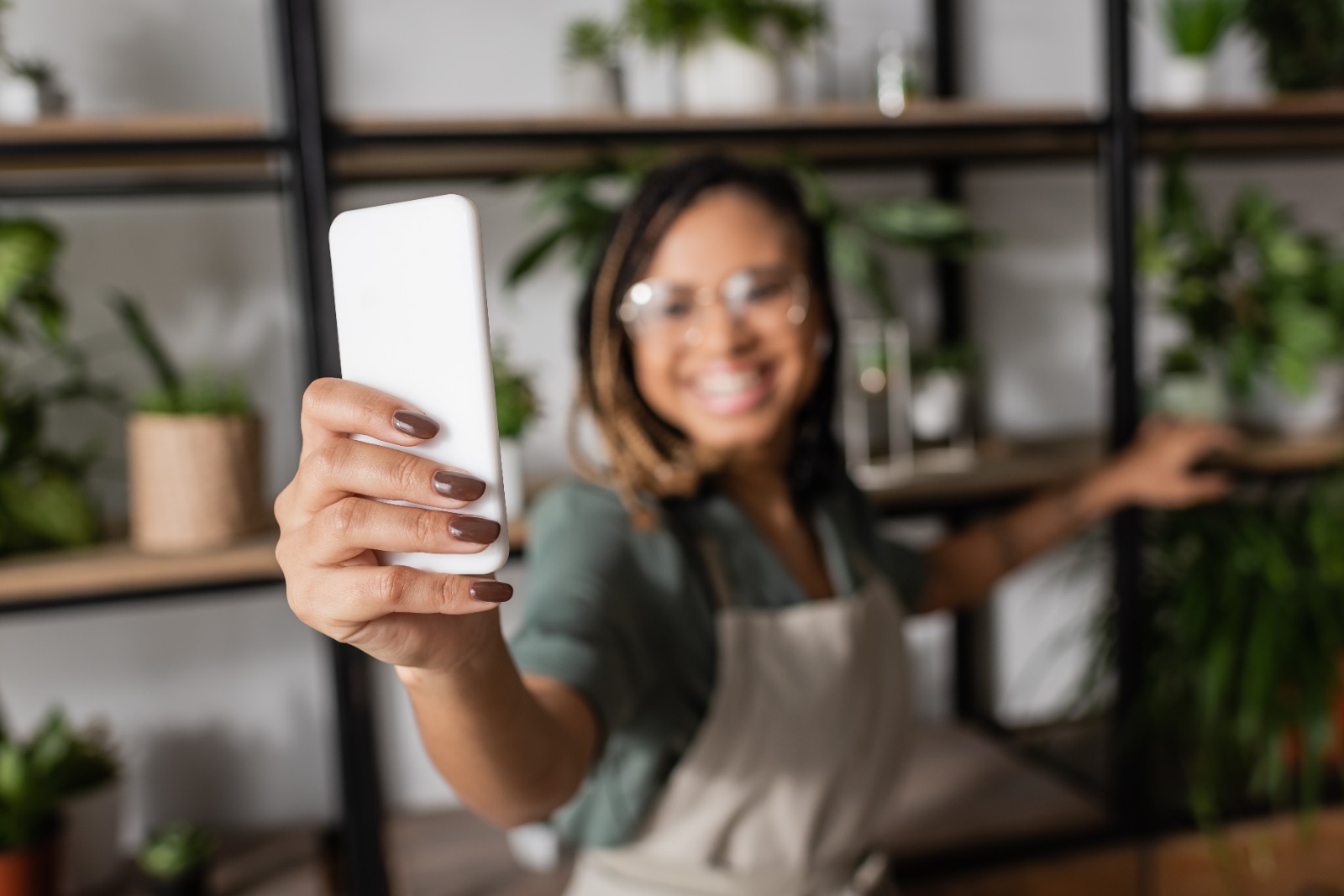 Pemilik usaha kecil memegang ponsel untuk menerima pembayaran online secara mudah, menggambarkan digitalisasi bisnis tanpa website.