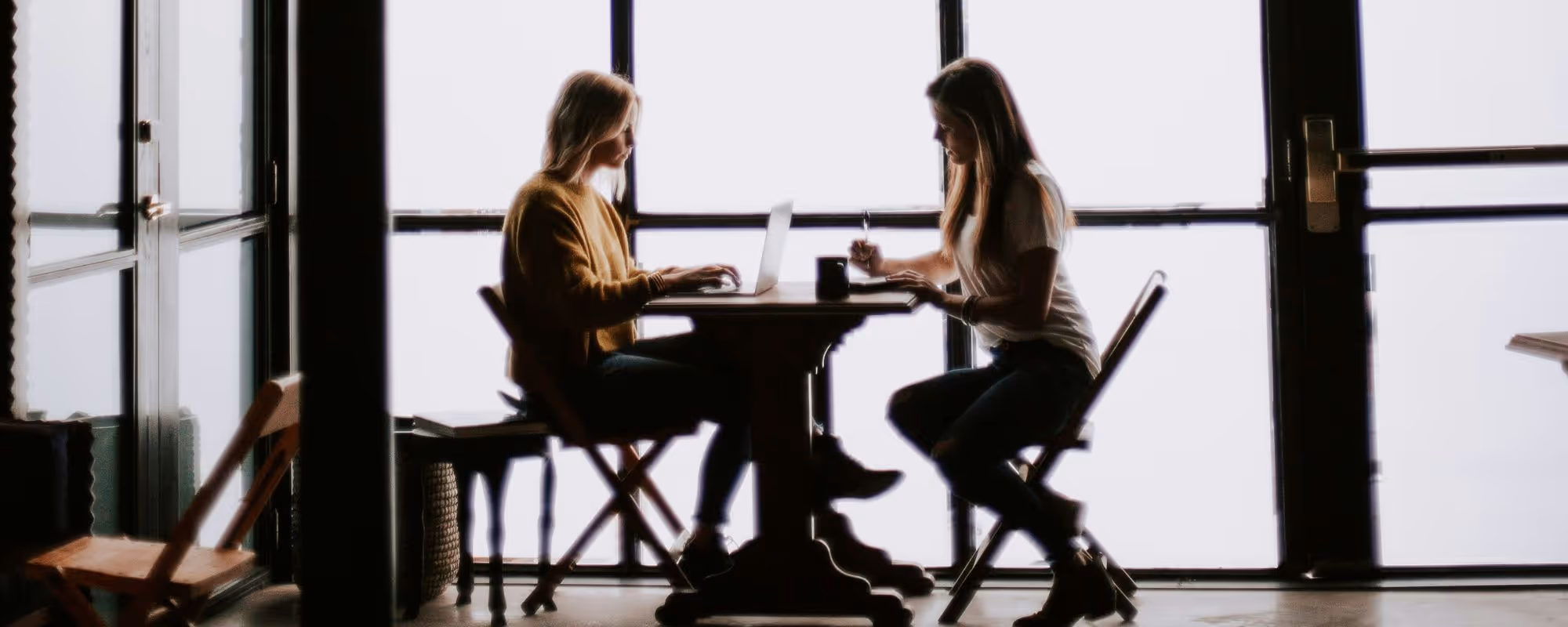 Two professionals sitting across from each other in office building.