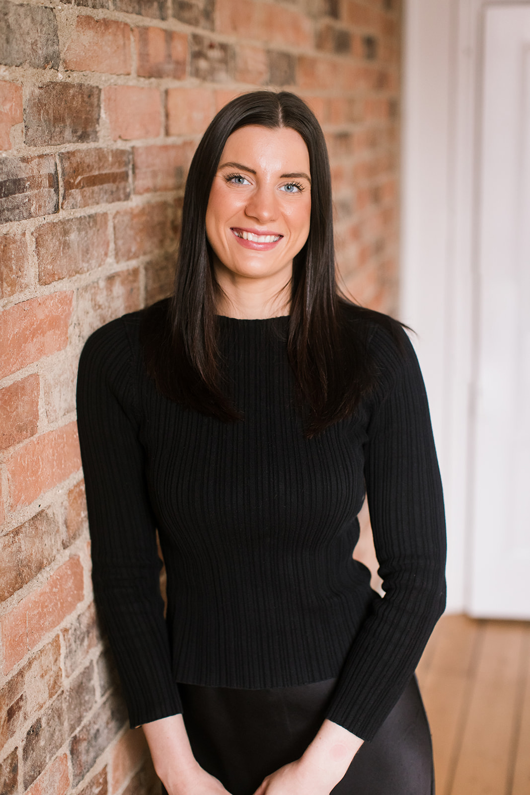 Pictured is Karlee Driessen a receptionist at Wakefield Lawyers. She is standing in front of a brick wall. 