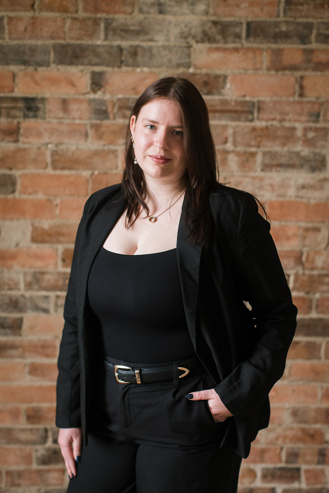 Pictured is Tahlia Witney who is a conveyancing assistant at Wakefield Lawyers. She is standing next to a brick background. 