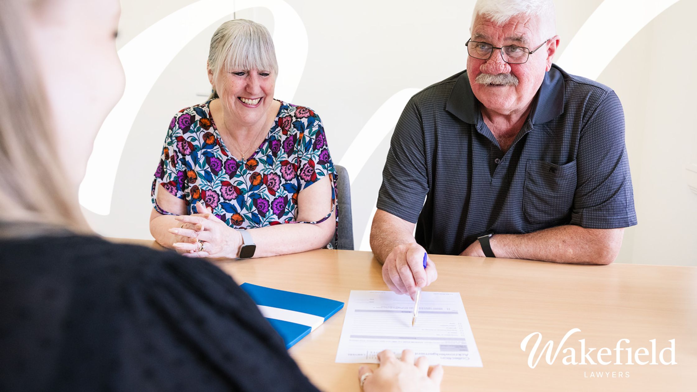 An older couple signing documents at Wakefield Lawyers