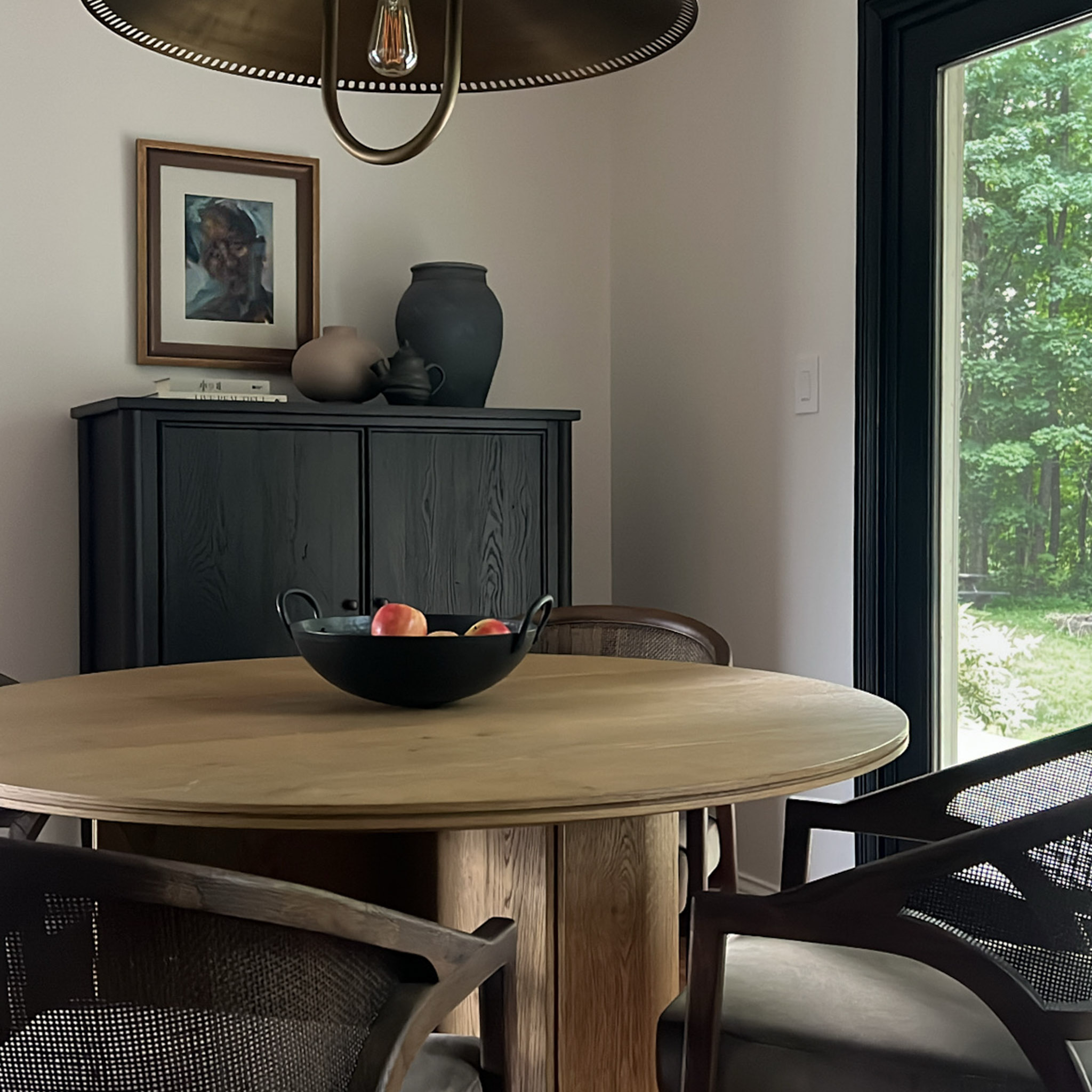 Interior view of a room with dark-framed glass double doors showing a backyard with autumn trees and yellow leaves.