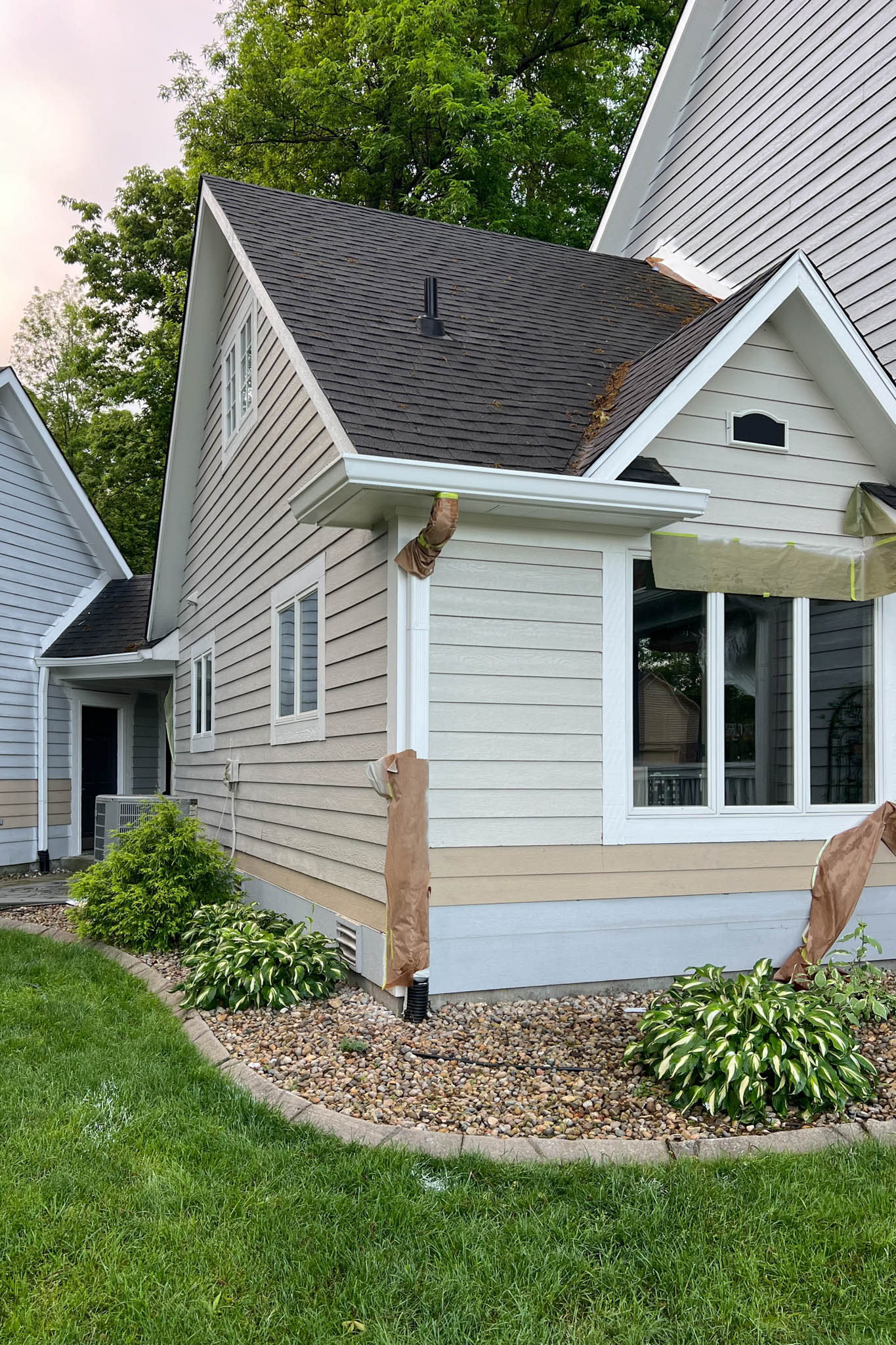 View of front of house with newly painted siding in beige.