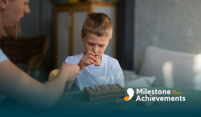 A female ABA therapist and autistic child playing together with educational blocks, focusing on the task at hand.