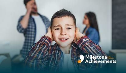 Autistic young boy covering his ears in distress while parents argue in the background after ABA therapy.