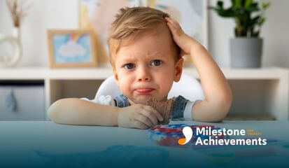 An autistic child looking confused while holding a sensory toy, unsure of what to do next during ABA therapy.