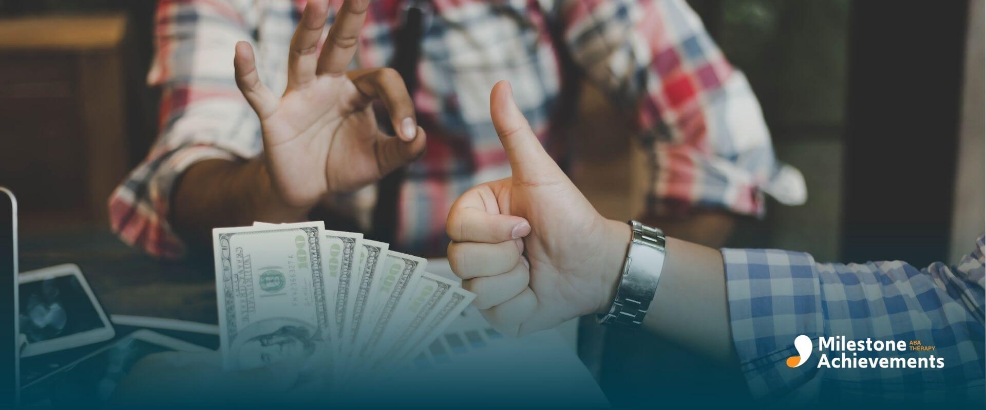 An ABA therapist exchanging cash over a laptop, symbolizing financial agreement, approval gesture, and business transaction.