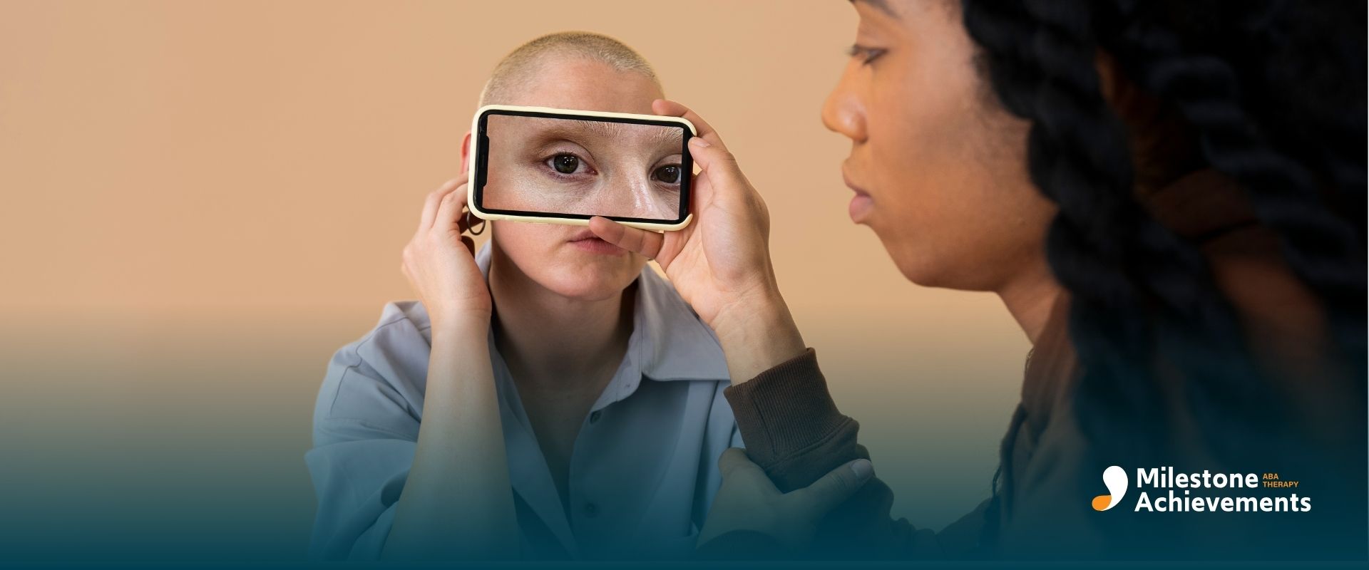 Two adults facing each other, one holding a smartphone over their face showing eyes, symbolizing identity, perception.