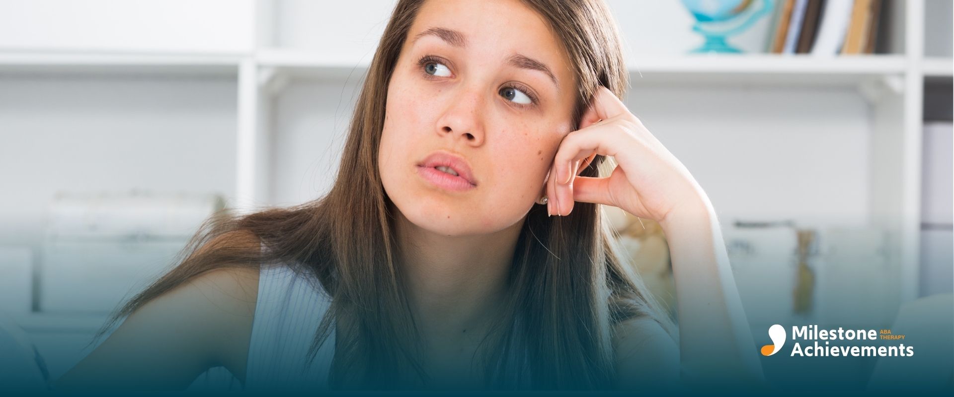 A therapist studying at desk with open books and notes, looking thoughtful and distracted in bright home office setting.