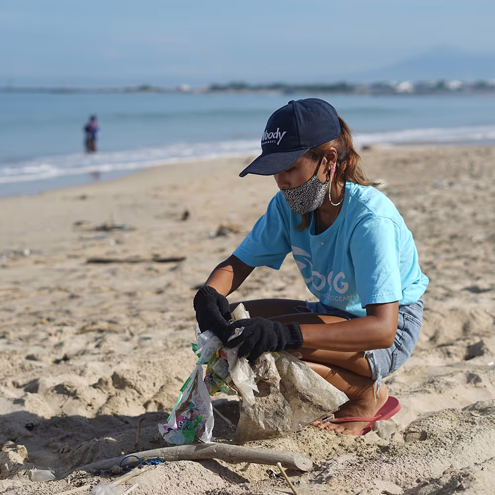 A girl collecting garbage on a beach