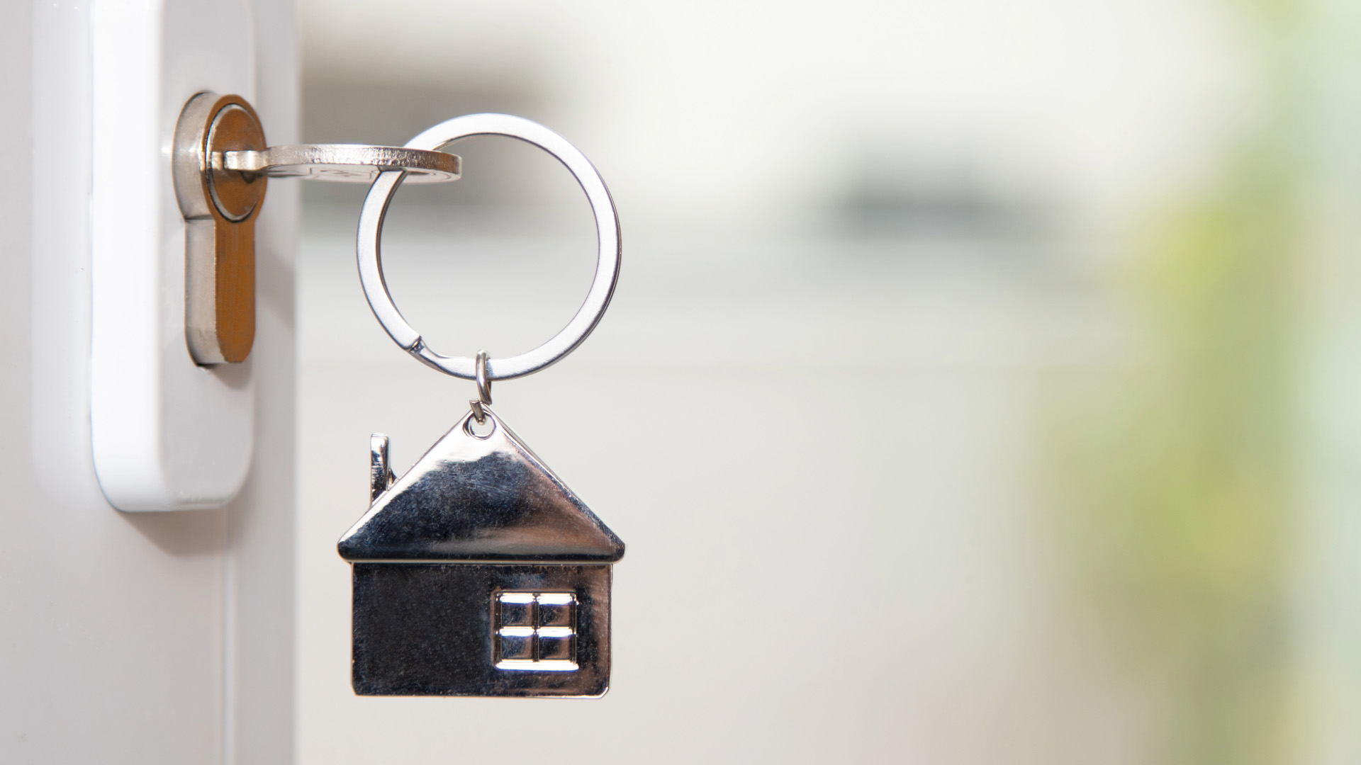 Key in door lock with house-shaped keychain attached