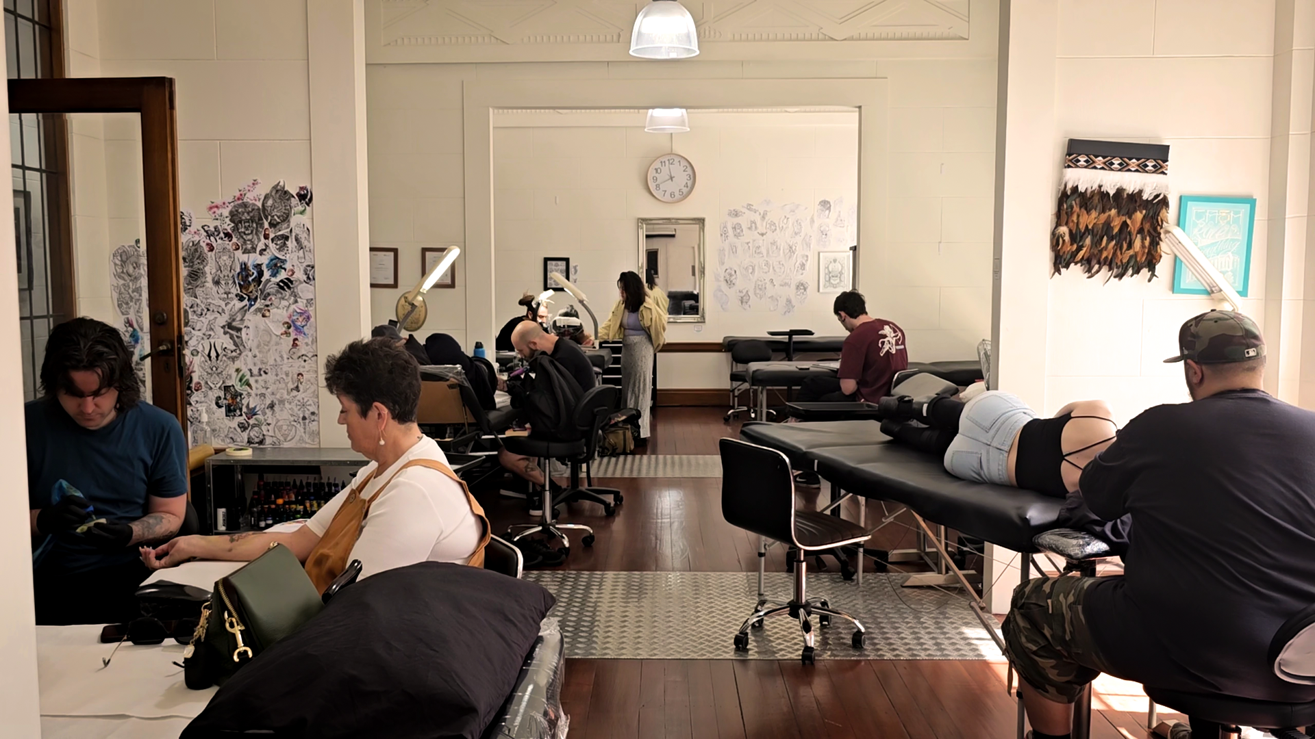 The tattoo studio filled with artists and clients.