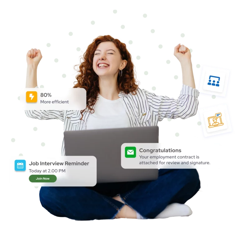 A young woman sitting cross-legged in front of a laptop,  arms raised in celebration, smiling — the moment of  receiving a job offer through GoHeadHunt.
