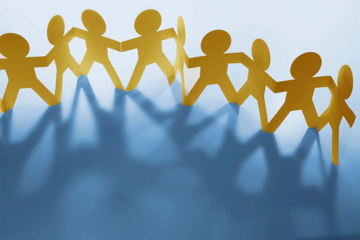 Cutouts of yellow paper people on a blue background