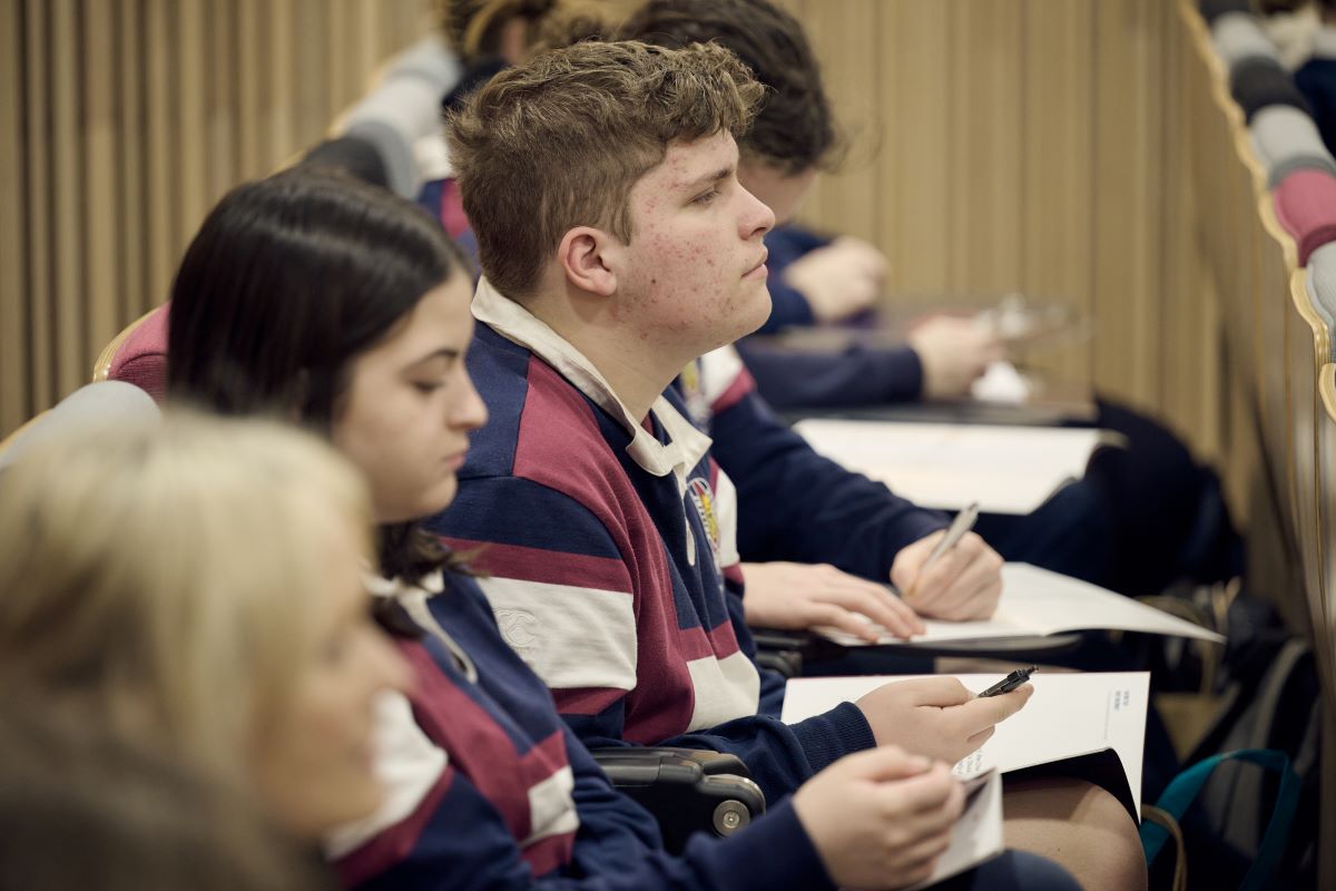 High school students listening to a presentation taking notes