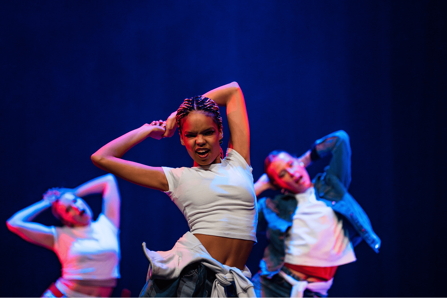 Two dancers, with one arm in the air. The dancers are facing each other