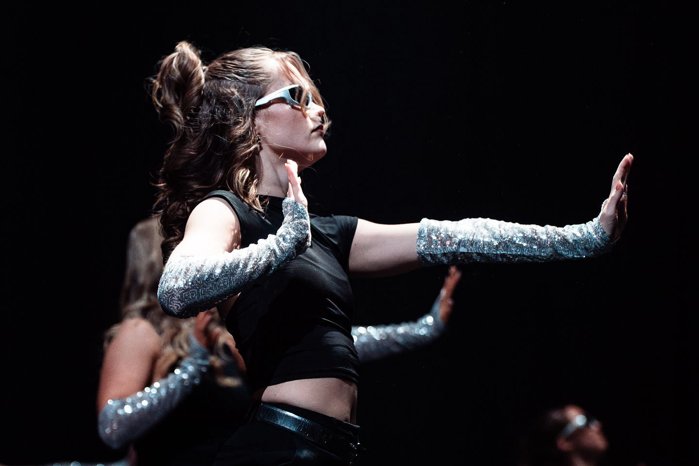 Dancers in a row with their hands up.
