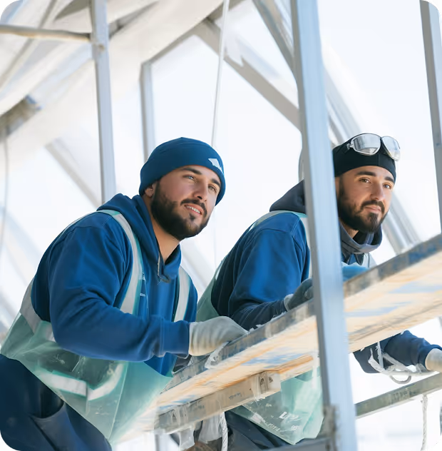 A man is vacuuming a tidy living room, focusing on the carpet while surrounded by furniture and decor.