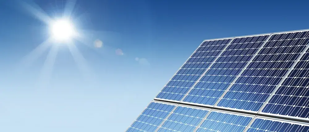 Solar panels in bright sunlight against a clear blue sky