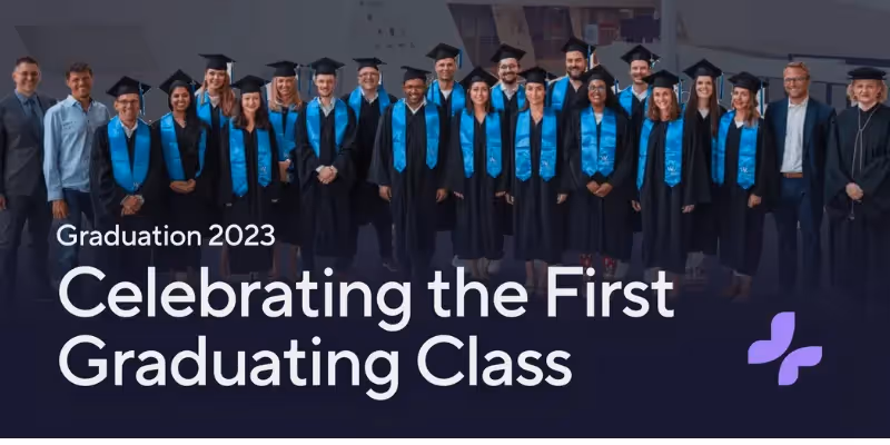 Absolventen in Talaren posieren als Gruppe mit der Fakultät während der Abschlussfeier 2023.