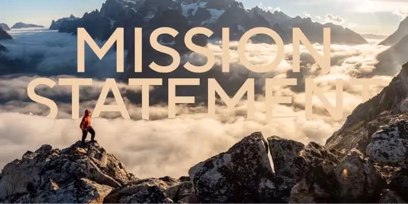 Person steht auf einem felsigen Berggipfel über einer Wolkenlandschaft mit dem Text 'MISSION STATEMENT'.