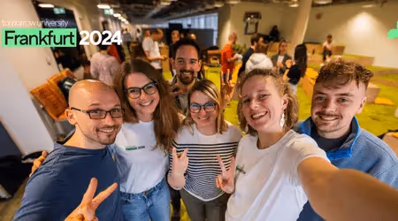 Group selfie of smiling Tomorrow University students and team at Frankfurt 2024 meetup.