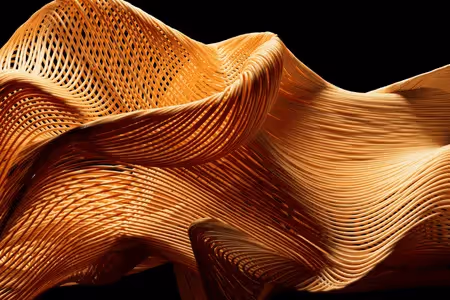 Close-up of intricately woven, sculptural wooden design with flowing, organic curves.