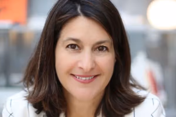 Kathryn Saducas, strategische Nachhaltigkeitsberaterin, lächelt in einem professionellen Umfeld.