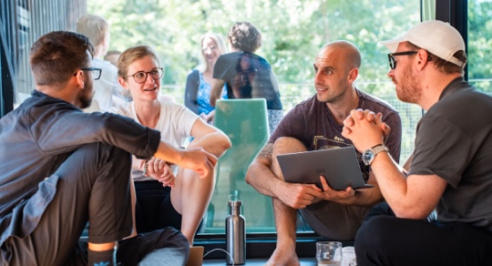 Kleine Gruppe von Menschen im Gespräch bei einem informellen Indoor-Event.