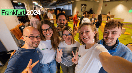 Eine Gruppe von Studierenden der Tomorrow University beim Meetup in Frankfurt, sie sehen glücklich aus, lächeln und machen ein Selfie.