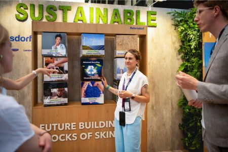 Frau erklärt Nachhaltigkeitsdisplays an einem Stand beim Green Tech Festival